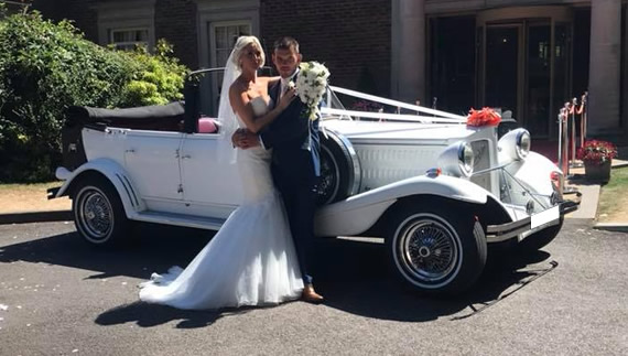 Bride and groom stand in front of Beauford outside of wedding venue