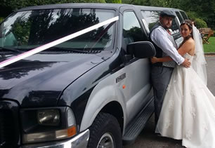 Bridesmaids pose with wedding car