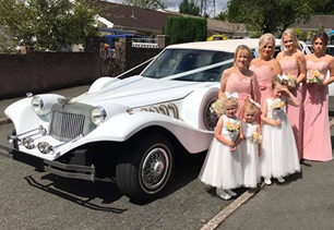 Bridesmaids pose with limousine