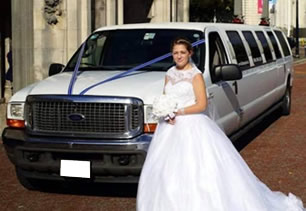 Bride stands with white wedding limousine in front of Cardiff City Hall